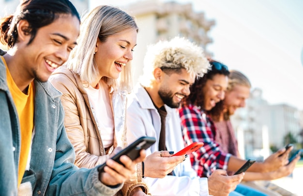 Trendy millenial friends using smartphone at campus college Young genz people sharing live content with mobile smart phone Tech life style concept with always connected millennials Bright filter