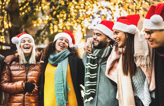 Trendy people group walking under Christmas tree decoration