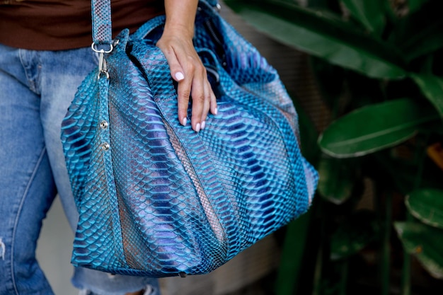 Trendy python classic blue leather big handbag in woman hands