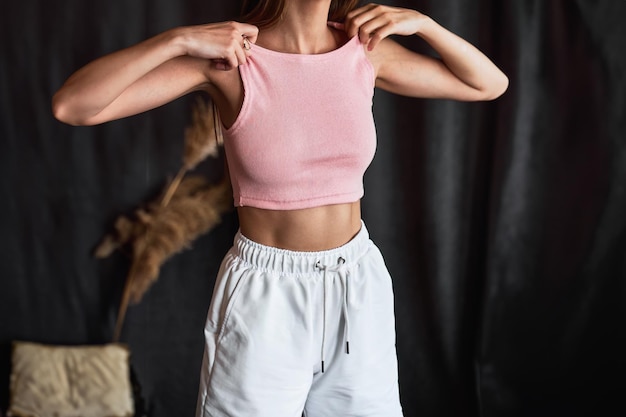 Photo trendy woman in white tank top and shorts posing in studio