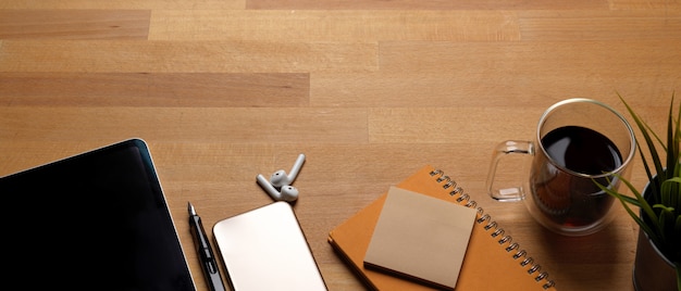 Photo trendy worktable with copy space, mock-up smartphone, tablet, coffee cup and stationery