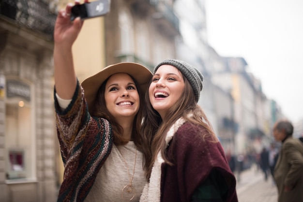 Trendy young women taking selfies in the city