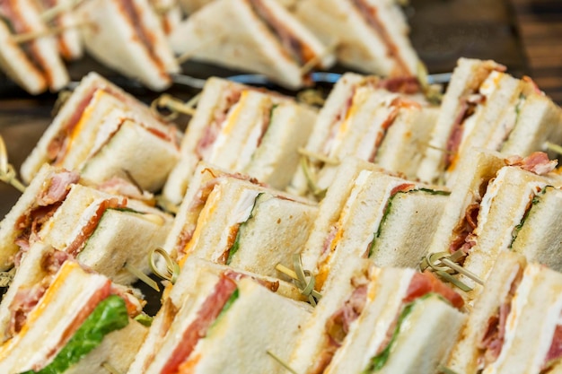 Triangular appetizing sandwiches on the buffet table Catering for events holidays and business meetings Closeup Selective focus