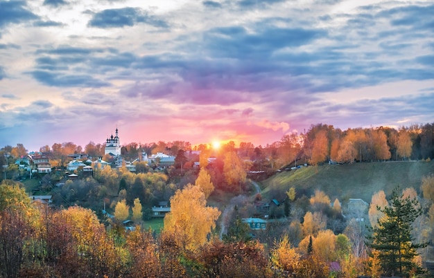 Trinity Church in Plyos and Cathedral Mountain against the backdrop of a pink sunset autumn sky