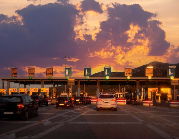 Trip on the toll highway Athens-Thessaloniki, past cars, toll checkpoints at sunset in Greece