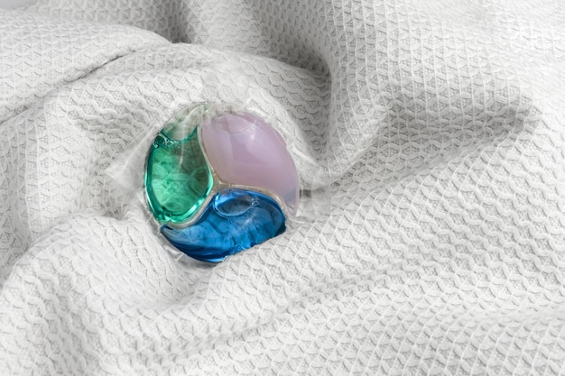 Triplecolored capsule for washing clothes on a white cloth