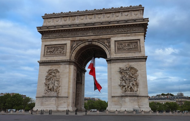 The Triumphal Arch decorated with French flag Paris France