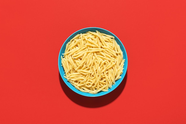 Photo trofie pasta bowl top view on a red background