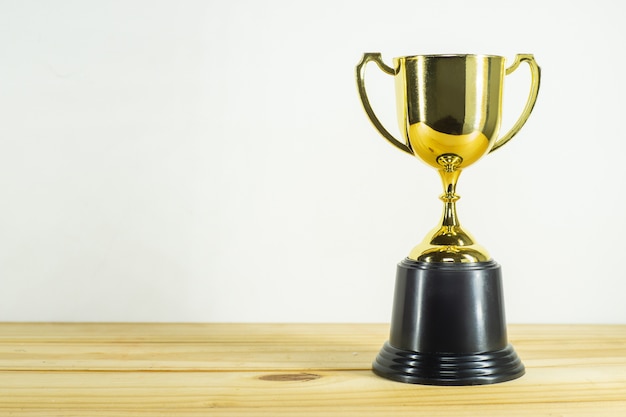 Trophy on top of old wooden table in front of blackboard.