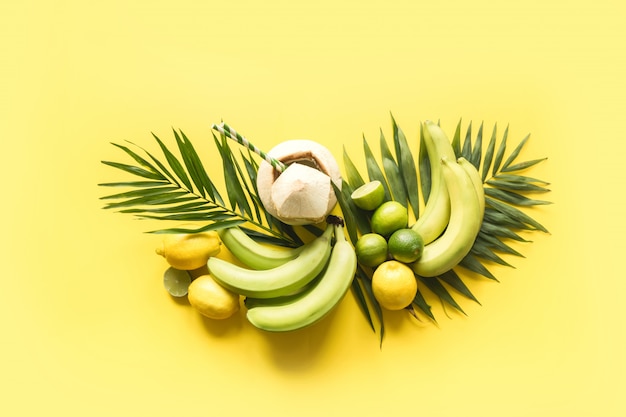 Tropical banner of fruits, banana, lime, leaves palms, fresh coconut