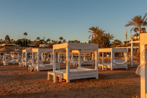 Tropical beach with umbrelles during sunset Tourism and travel