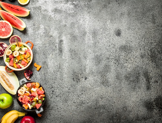 Tropical food . Fresh tropical fruit salad in bowls. On rustic background.