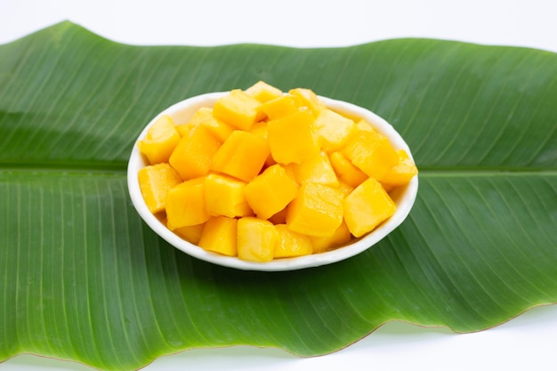 Tropical fruit, Mango cube slices in white bowl on banana leaf