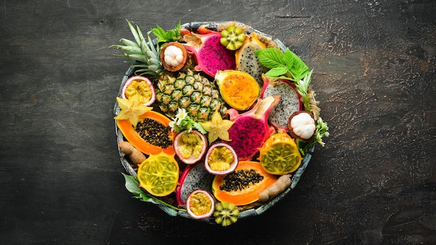 Tropical fruits on a brown background papaya mangosteen cactus fruit pytahaya pineapple Top view Free space for text