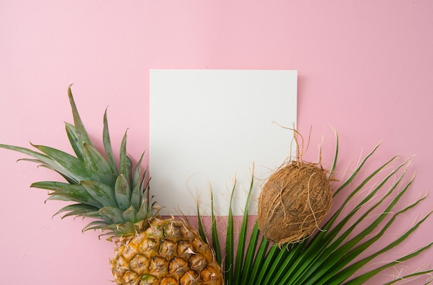 tropical fruits and leaves on a pink background top view