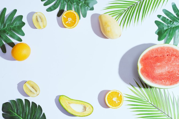 Tropical fruits like mango, orange, watermelon, avocado are arranged on a white background