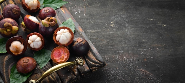 Photo tropical fruits mangosteen on a wooden background top view free space for text