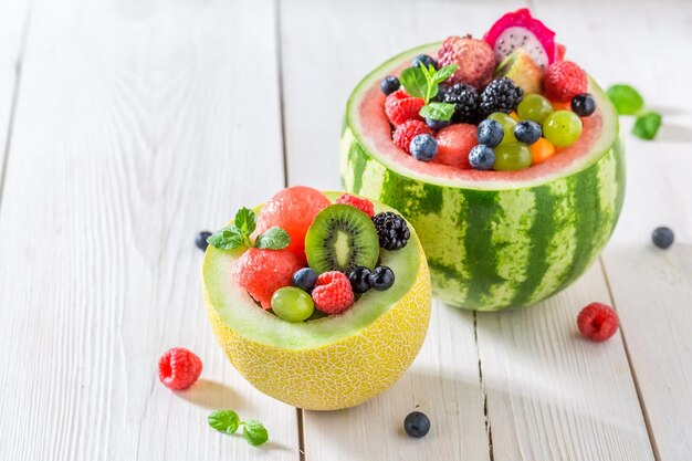 Tropical fruits salad in melon and watermelon in sunny kitchen