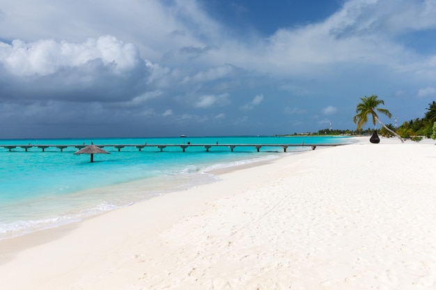 Tropical Maldives island with white sandy beach and sea