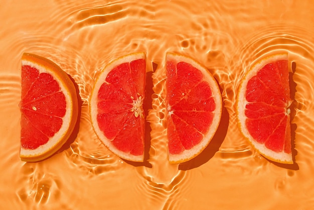 Tropical parts grapefruit fresh organic with vitamins in liquid water with wave motion