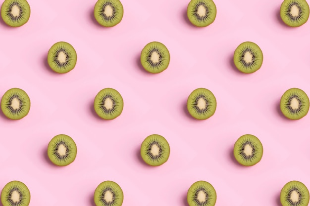 Tropical seamless pattern of kiwi slices on pink