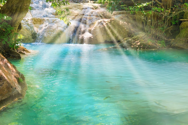 Tropical waterfall with emerald lake in jungle forest