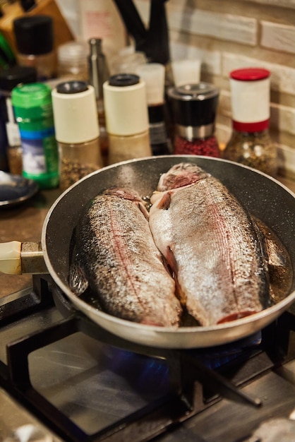 Trout is fried in pan on gas stove