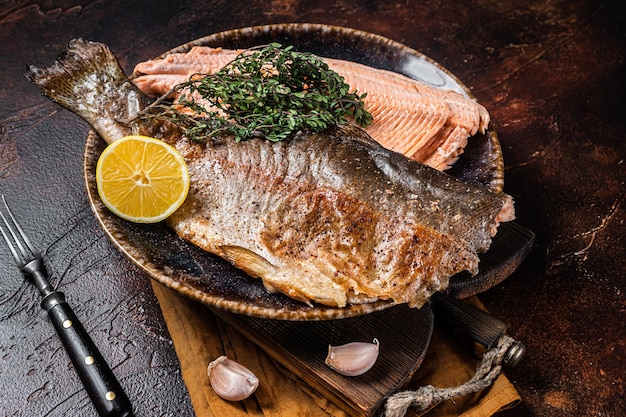 Trout roasted fillet grilled fish on a plate with thyme and lemon Dark background Top view