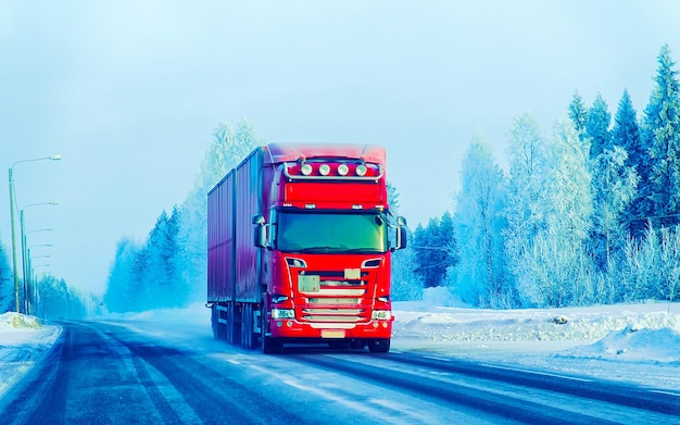 Truck in snow winter road of Finland. Trucker in highway. Lorry doing logistics work. Semi trailer with driver. Big cargo car drive. Freight delivery. Transport export industry. Container with goods