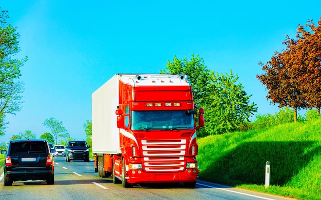 Truck in summer road of Czechia. Trucker in highway. Lorry doing logistics work. Semi trailer with driver. Big cargo car drive. Freight delivery. Transport export industry. Container with goods