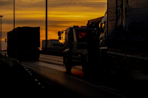 Truck with Cargo driving on road transportation highway at sunset in summer