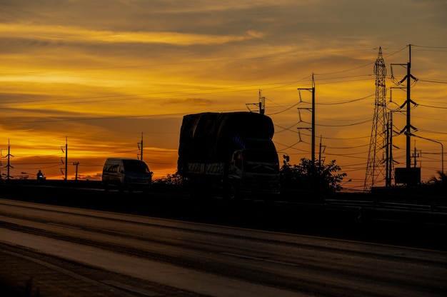 Truck with Cargo driving on road transportation highway at sunset in summer