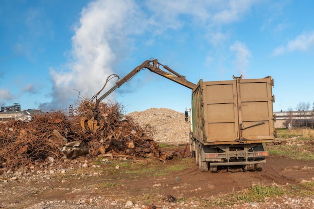 A truck with a forklift in front of a pile of rubble