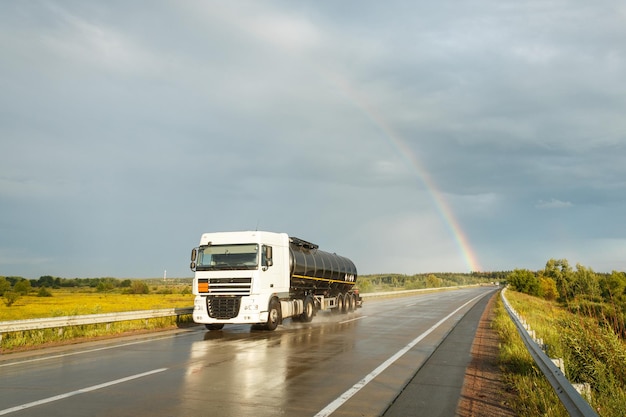 Truck with a tank cistern moving on a wet road