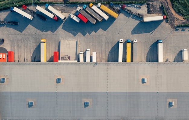 Trucks with trailers are loaded and unloaded in the cargo terminal in the morning top vu airive shot...