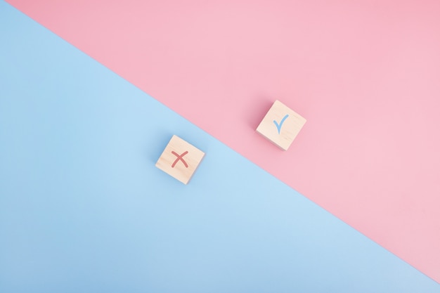 True and false icon accepted rejected, Yes or No on wood cubes. pink and blue background.