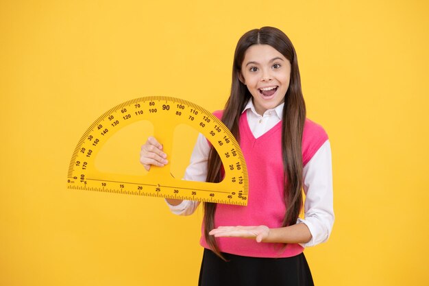 Photo try this child with protractor angle degree measurement surprised teen girl hold ruler back to school algebra and geometry kid study math stem disciplines concept of education