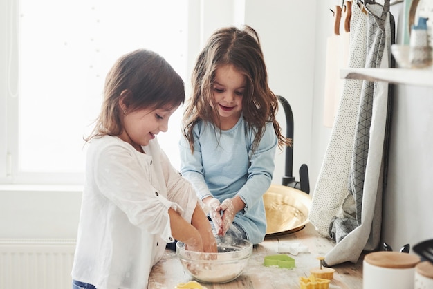 Trying to recreate what they were taught. Preschool friends learning how to cook with flour in the white kitchen.