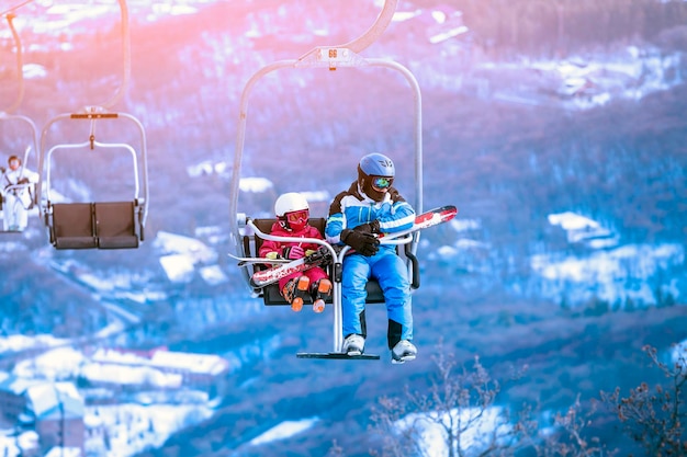 Tsakhkadzor Armenia January 2021 a skier with a skiers little son climb the mountain by cable car