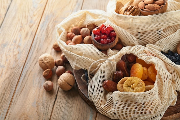 Tu Bishvat celebration concept Mix of dry fruits and nuts almonds hazelnuts walnuts apricots prunes cherries raisins dates apples figs over wooden table Jewish holiday new year of trees