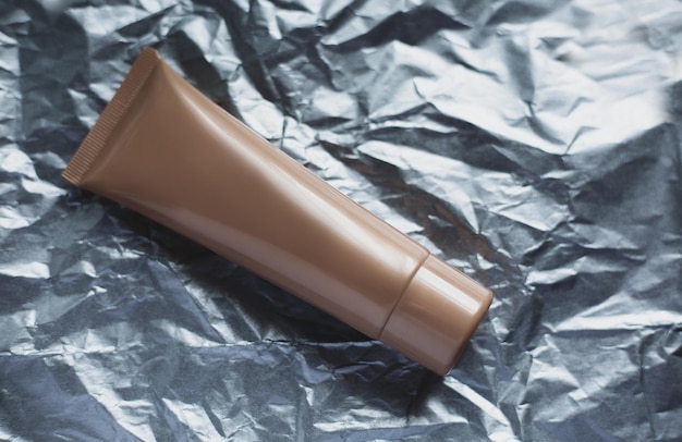 Tube of face cream on a silver background