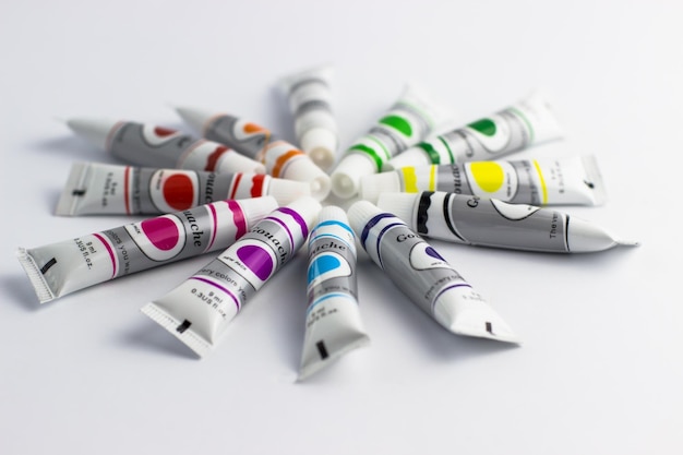 Tubes of paint folded by the sun on a white background Colorful paints Children's creativity