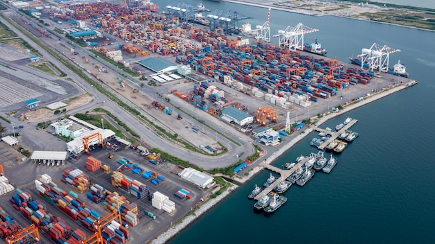 Tugboat parking in a row in sea and container shipping port background