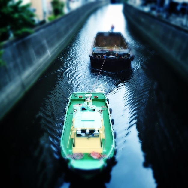 Photo tugboat pulling barge in canal