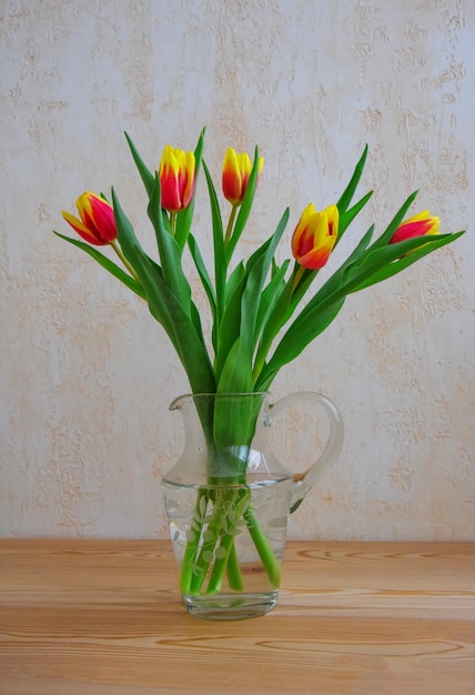 Tulip flowers for birthday celebration Tulips in vase on wooden table Mothers day concept