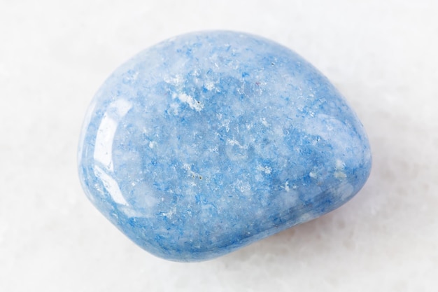 Tumbled blue Aventurine gem stone on white marble