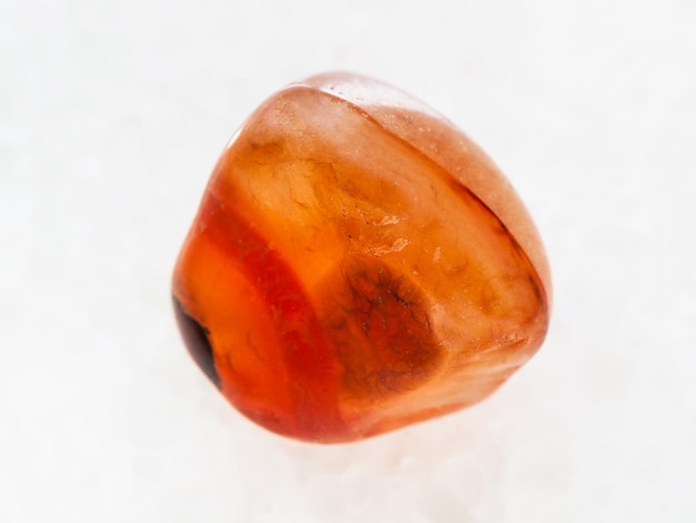 Photo tumbled carnelian gem stone on white marble