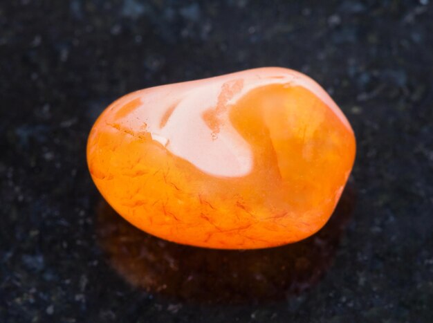 Photo tumbled carnelian gemstone on dark background