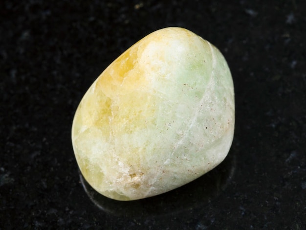 Tumbled Datolite gemstone on dark background