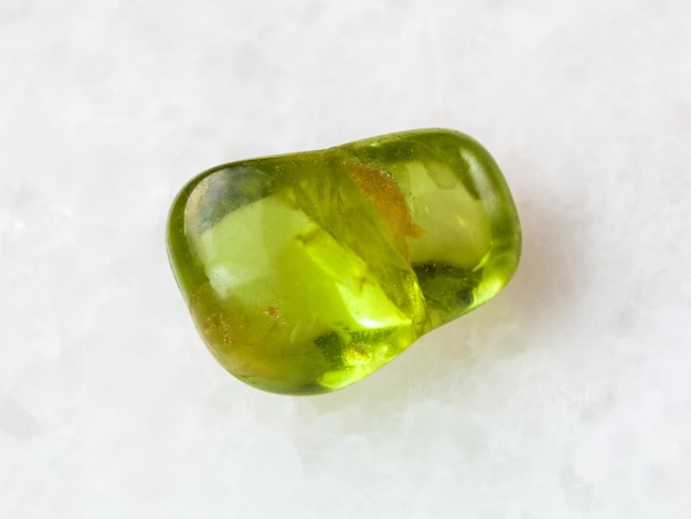 Tumbled Peridot gem stone on white